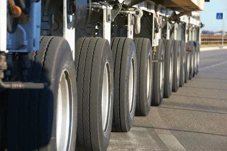 closeup of 18-wheeler tires carrying trucking insurance limits for minimum financial responsibility