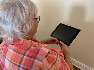 Elderly person holding tablet